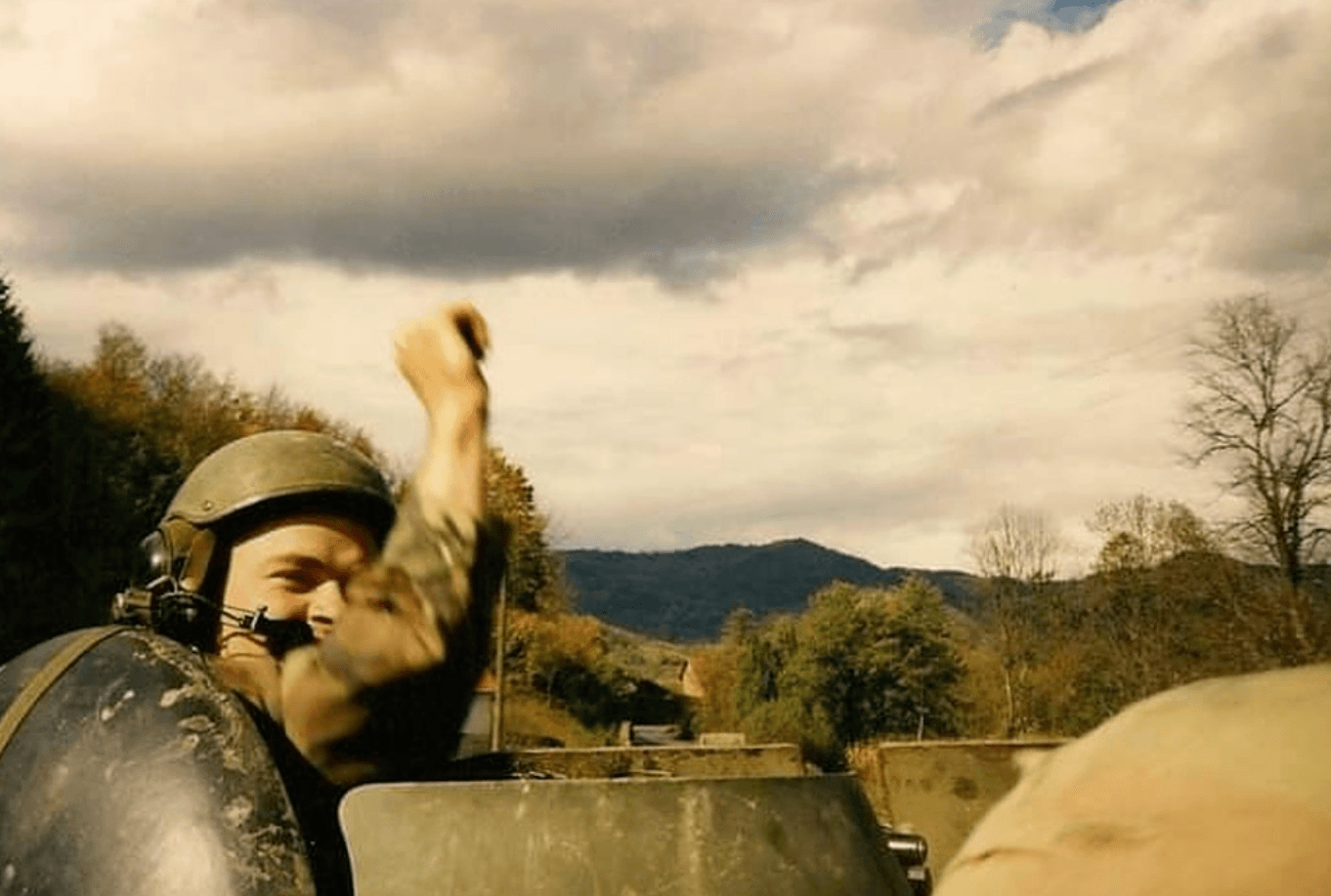 SSG Omer T. Hawkins II, waves from his tank in Bosnia in 1996.
